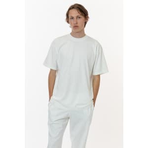 A white short sleeve garment dye crewneck tee, styled with a relaxed fit, shown on a model with matching trousers.