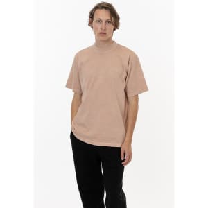 A crewneck tee in a soft peach colour, featuring short sleeves and a relaxed fit. It has a branding logo.