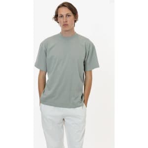 A short sleeve crewneck tee in a soft green colour, featuring a simple design and a logo.