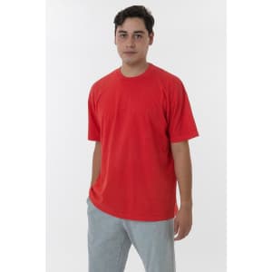 A red short sleeve crewneck tee displayed on a model, paired with grey trousers. The shirt has a logo.