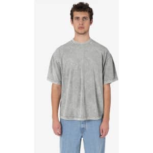 A man wearing a grey short sleeve mineral wash crew tee, styled with loose jeans. The shirt has a simple design and visible stitching.