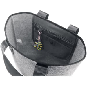 A grey reusable grocery bag with a zippered pocket and a colourful charm attached inside.