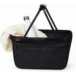 A black shopper bag with a white drink bottle and a cream blanket inside. The bag features a logo on it.