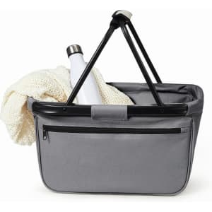 A grey tote bag with a black handle, featuring a drink bottle and a knitted item inside. It has a front zip pocket and a branding logo.