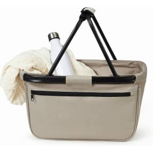 A beige shopper bag with a black handle, featuring a drink bottle and a soft blanket inside.