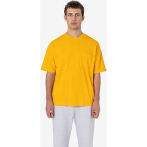 A yellow short sleeve pocket tee worn with grey pants, featuring a basic design and a logo.