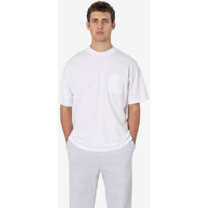 A white short sleeve T-shirt featuring a pocket, worn with grey trousers. The shirt has a subtle logo on it.