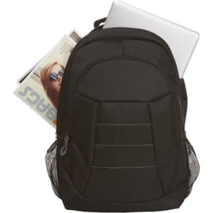 A black laptop backpack with a silver laptop partially visible and a magazine peeking out from the top. It features side mesh pockets.