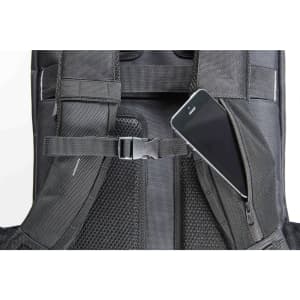 A black backpack with a zippered compartment, featuring a smartphone tucked inside. It has a logo on the side.