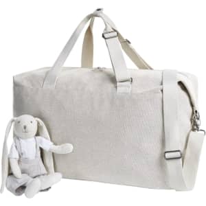 A light grey duffle bag sits beside a soft toy rabbit wearing a shirt and shorts. The bag has a shoulder strap and logo.