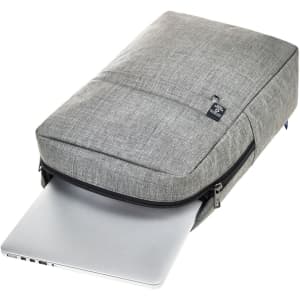 A grey laptop backpack with a zip closure, showcasing a laptop partially inserted into the pouch. It features a logo.