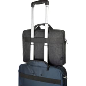 A black laptop bag is stacked on a blue suitcase, featuring a handle and a strap for easy transport.