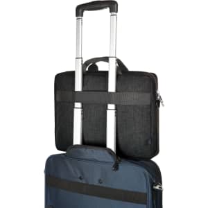 A laptop bag in black with handles and straps, positioned on top of a blue suitcase. It features a logo.