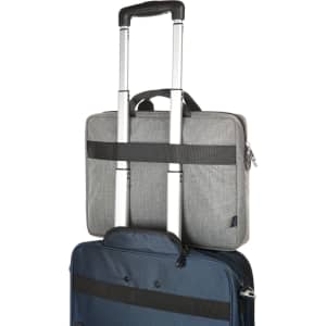 A grey laptop bag with black straps, stacked on top of a blue suitcase with telescopic handles.