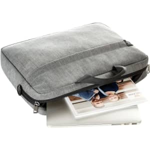 A grey laptop bag with a handle, featuring an unzipped opening and a visible laptop inside. It has a logo.