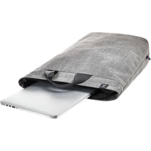A grey laptop backpack with a laptop partially visible inside and carry handles. It features branding on the exterior.