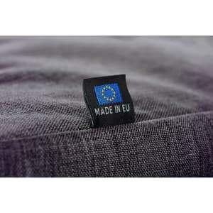 A close-up of a grey fabric showing a label with a flag and the text "MADE IN EU".