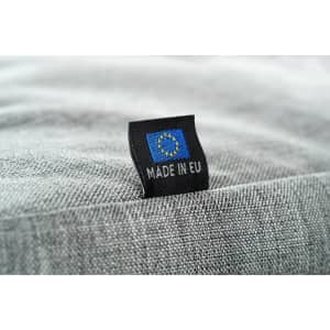 A grey fabric featuring a tag with a logo and the text "Made in EU."