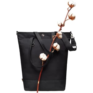 A black tote bag with dual handles and an adjustable strap, adorned with a cotton branch. It features a logo.