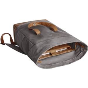 A grey backpack with tan straps, featuring an open top revealing a padded laptop compartment inside.