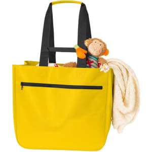 A yellow tote bag with black straps, holding a plush monkey toy and a blanket. The bag features a zippered pocket.