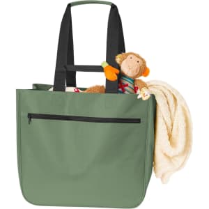 A green tote bag with black straps, featuring a stuffed monkey and a blanket inside.