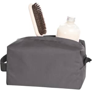 A grey toiletry bag containing a brush and a bottle, featuring a handle and a logo.