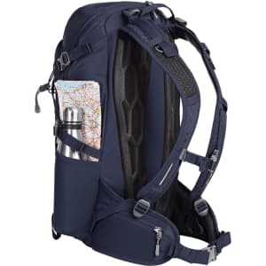 A navy outdoor backpack features a drink bottle in a side pocket and a map tucked into the mesh back.