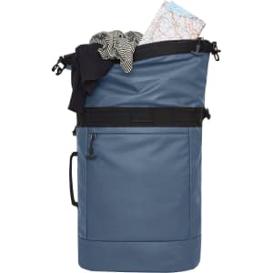 A blue backpack filled with a striped shirt and a map, featuring a front pocket and a logo.