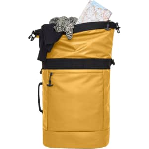 A yellow backpack with a black strap, featuring folded clothing and a map peeking out from the top.
