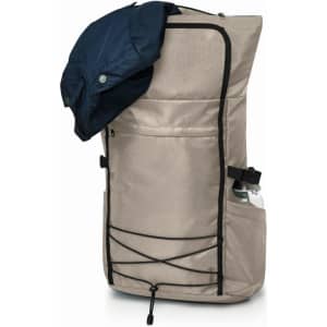 A beige laptop backpack with a navy jacket draped over it, featuring a side water bottle pocket and a front pouch.