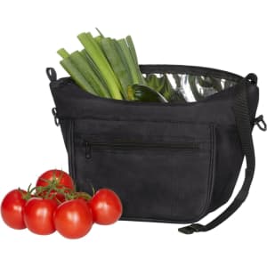 A black Softbasket Lunchbag with green leeks and zucchini inside, alongside fresh red tomatoes. Features a logo.