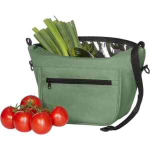 A green lunch bag filled with leeks and cucumbers, alongside a bunch of ripe red tomatoes. The bag features a zippered pocket and a logo.
