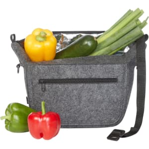 A grey felt lunch bag with a zippered pocket, filled with yellow, green, and red peppers, and a zucchini.