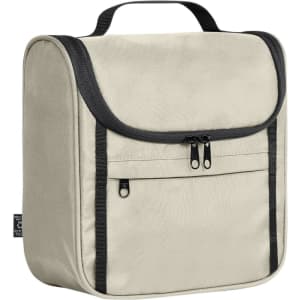 A beige toiletry bag with a zipped front pocket, featuring a handle and black accents, and a subtle logo.