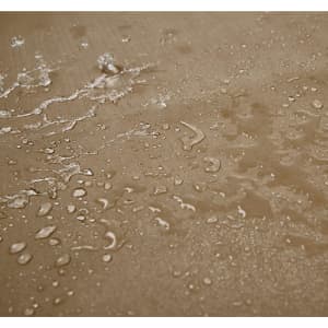 A close-up of a textured surface with water droplets, showcasing a sandy brown colour and a waterproof finish.