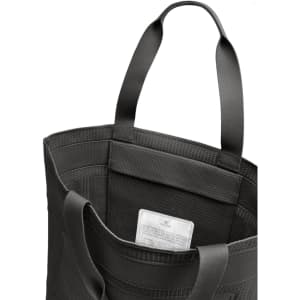 A black tote bag with two handles, featuring a textured interior and a visible label inside.