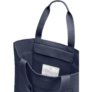 A navy tote bag with two handles, featuring a textured design and an interior pocket.