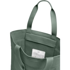 A green tote bag with sturdy handles and a textured design, featuring an interior label and a spacious opening.