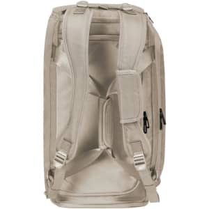 A beige duffle bag with adjustable straps and multiple zippered pockets. It features a logo on the side.