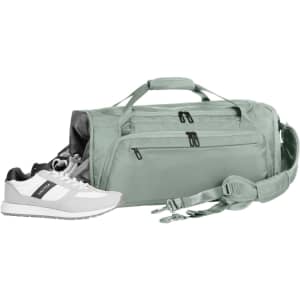 A light green duffle bag with two zippered pockets, accompanied by a pair of white athletic shoes.