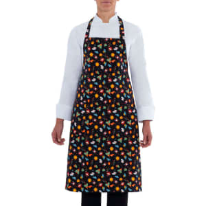 A floral-patterned apron featuring a black background with multicoloured flowers, worn by a person in a white shirt.