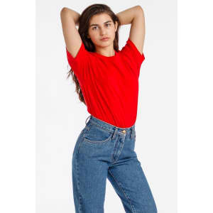 A model poses in a red short sleeve fine jersey crew tee paired with high-waisted blue jeans.