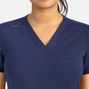 A navy blue women's banded V-neck top with a chest pocket and a small logo detail.