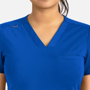 A blue women's banded V-neck top featuring a small pocket and a logo on the shoulder.
