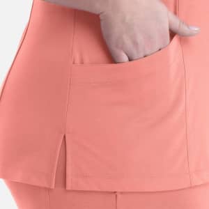 A close-up of a coral women's curved V-neck top featuring a side slit and a pocket.