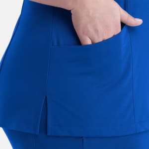 A blue women's curved V-neck top featuring a side pocket and split detailing at the hem.