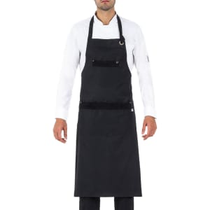 A black apron featuring pockets and a neck strap, worn by a person in a white shirt. The product has a logo.