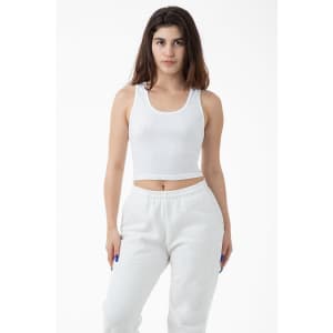 A cropped tank top in white, featuring a fitted design and a round neckline. The model pairs it with white sweatpants.