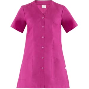A pink tunic with short sleeves, featuring a button-up front and two front pockets. It has a branding logo.